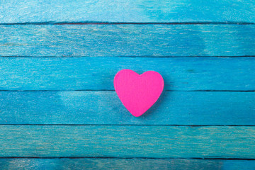 Decorative pink heart on blue wooden background