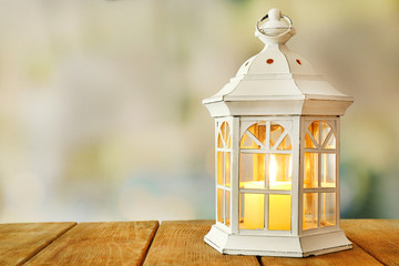 Lantern on wooden surface and blurred background © Africa Studio