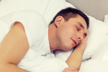 Obraz na płótnie Canvas handsome man sleeping in bed