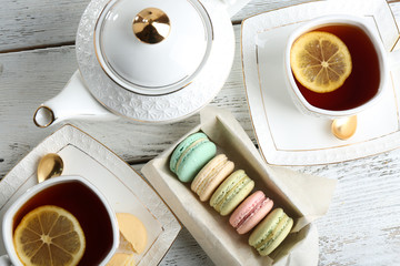 Colorful macaroons with teapot and cup of tea