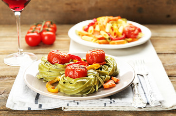 Two kinds of tasty pasta with pepper, carrot and tomatoes