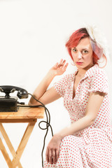 Redhead woman with a retro look waiting for the phone