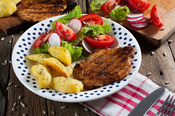 Grilled meat with salad and roasted potatoes