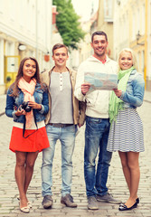 Fototapeta premium group of smiling friends with map and photocamera