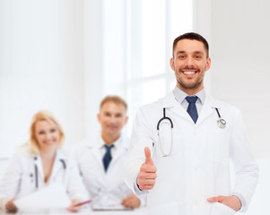 smiling doctor with stethoscope showing thumbs up