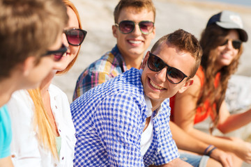 Obraz premium close up of smiling friends sitting on city street