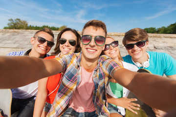 group of smiling friends making selfie outdoors