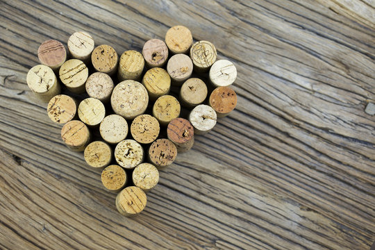 Wine corks form a heart shape image on the wood board background