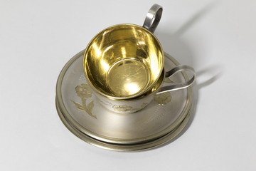 Two metallic saucer and coffee cup in stack