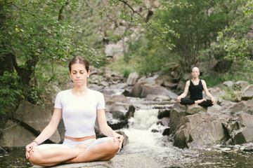 Woman and man doing yoga in nature