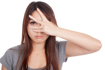 Fototapeta premium Young Asian woman peeking though her fingers