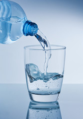 Mineralwasser in Wasserglas leeren