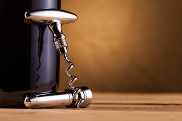 wine bottle and corkscrew on table
