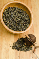 green tea, dried leaves with filter, on wooden background