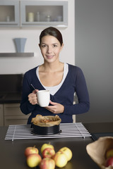 Junge Hausfrau mit einem selbstgebackenen Apfelkuchen