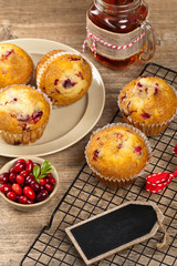Muffins with cranberry on cooling rack on wooden background