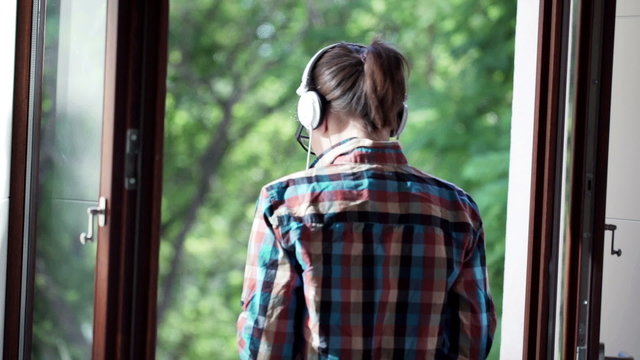 Young geek woman listening to music on cellphone