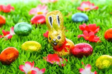 Ostern: Schokoladenhase auf Wiese mit Ostereiern