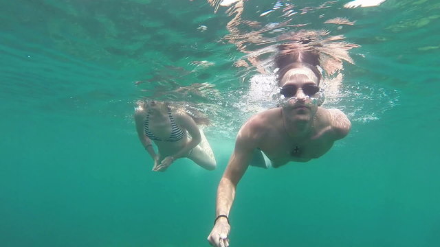 Young couple swimming together in open sea