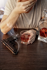 Devastated man with a gun and alcohol