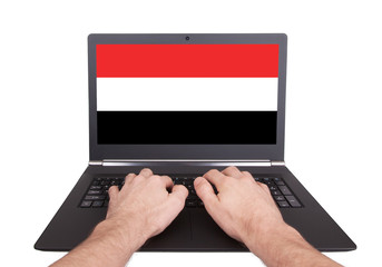 Hands working on laptop, Yemen