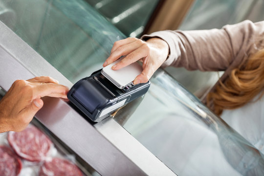 Customer Making Payment Through Smartphone In Butchery