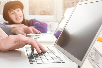 Laptop using in an home-office with young people.
