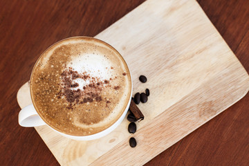 Hot coffee on wooden table in coffee shop.