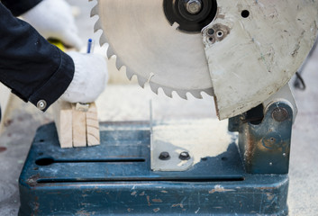 Carpenter cutting wood with electric saw