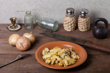 Onion, roasted potato, knive, salt, pepper and other things on t