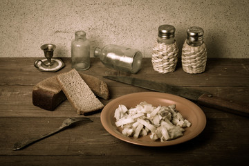 Onion, roasted potato, knive, salt, pepper and other things on t