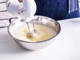 Mixing  egg cream in bowl with motor mixer, baking cake