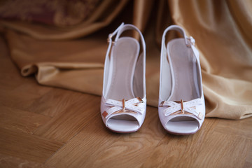 Obraz na płótnie Canvas Women's white sandals stand on a floor