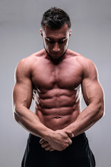 Portrait of young bodybuilder man over gray background