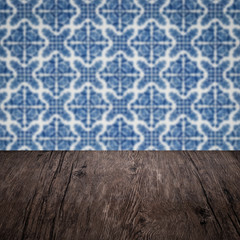 Wood table top and blur vintage ceramic tile pattern wall