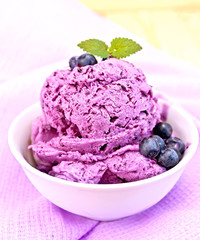 Ice cream blueberry with mint in bowl on purple napkin