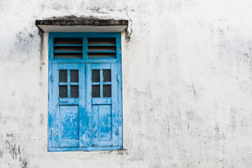 Fototapeta na wymiar Blue wooden window and grunge wall