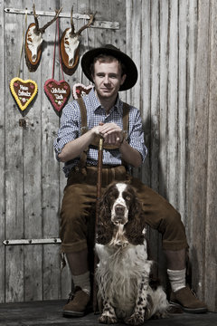 junger Mann in Lederhose mit einem Hund
