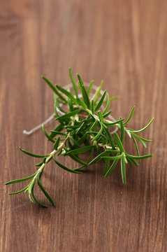 Fresh rosemary on the wooden table, selective focus