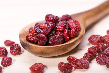 dried cranberries in a wooden spoon. fruit full of vitamin c.