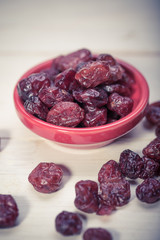 dried cranberries in a wooden spoon. fruit full of vitamin c.