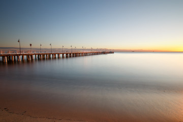 Fototapeta na wymiar Beautiful colorful Sunrise on the pier at the seaside