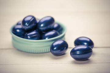 Cod liver oil omega 3 gel capsules isolated on wooden background