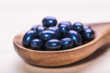 Cod liver oil omega 3 gel capsules isolated on wooden background