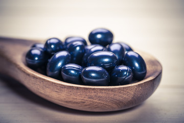 Cod liver oil omega 3 gel capsules isolated on wooden background