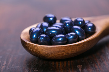 Cod liver oil omega 3 gel capsules isolated on wooden background