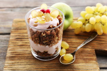 Healthy layered dessert with muesli and berries on table