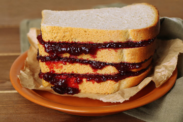 Tasty sandwich with jam on wooden table