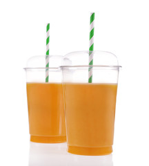Orange juice in fast food closed cups with tubes isolated