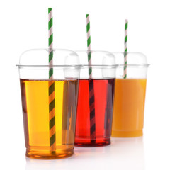 Fruit juices in fast food closed cup with tube and slices